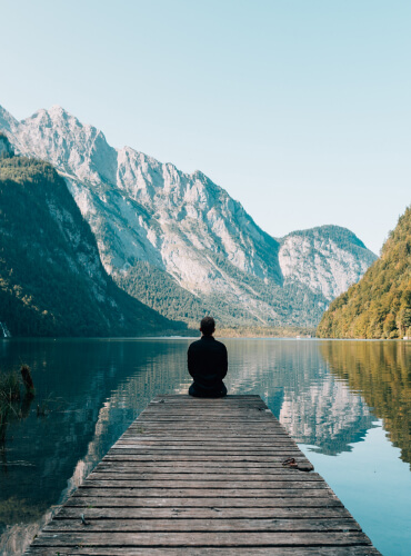 man sitting near lake